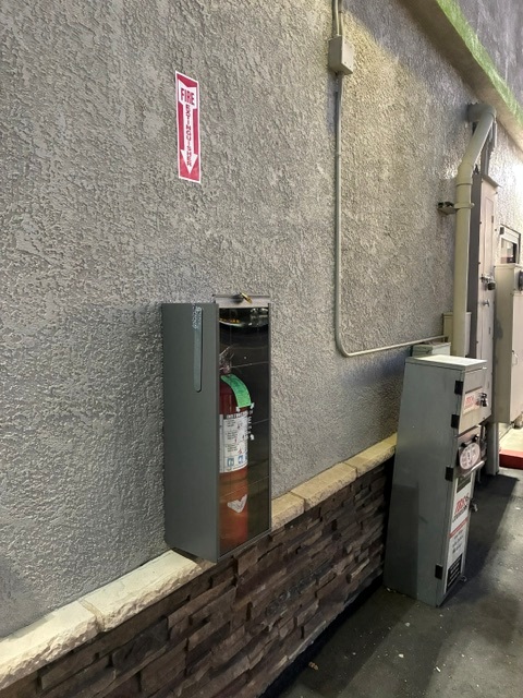 Wall-mounted fire extinguisher cabinet with inspection tag at a Sacramento commercial building