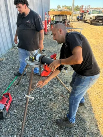 Fire protection technicians cutting and threading pipe for a fire sprinkler system in Sacramento
